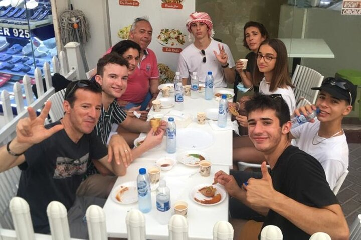 Experience the lively essence of Dubai as you savor local dishes with fellow travelers enjoying authentic flavors and creating lasting memories in a welcoming setting.